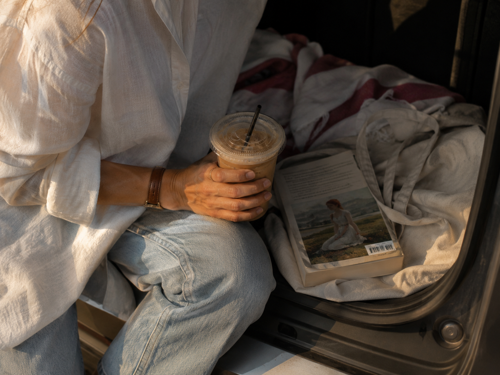 Close-up of iced coffee, a paperback book and a canvas tote during a spontaneous Labor Day weekend drive.