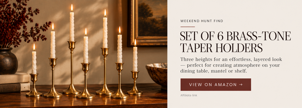 Slim brass-tone taper candle holders in several heights arranged together with ivory candles.