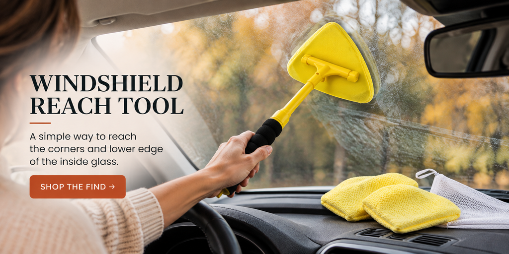Yellow Invisible Glass Reach and Clean tool being used to clean the inside of a car windshield.