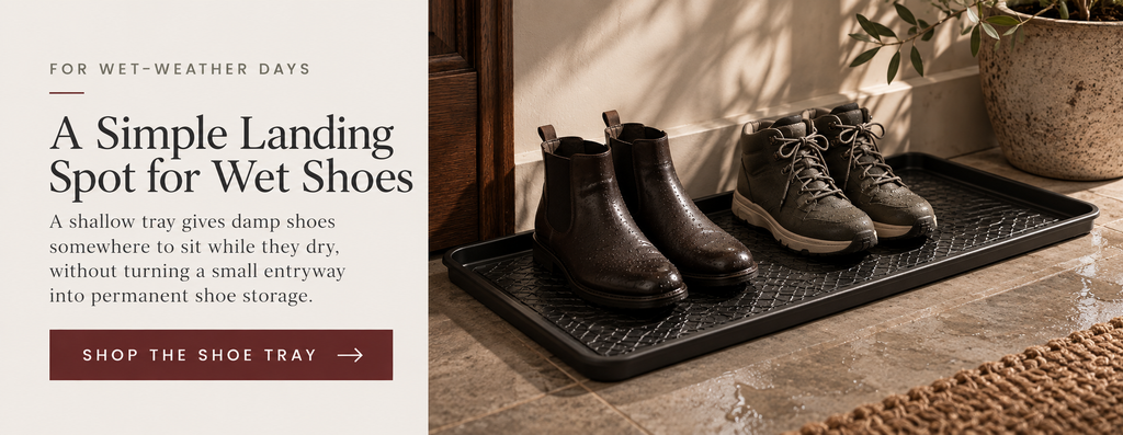 Editorial product card featuring a black boot tray for keeping wet-weather shoes together in a small entryway.