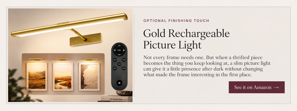 Slim gold rechargeable picture light with wall mount and black remote control.